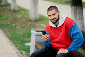 Fototapeta premium young man sitting on bench in park