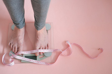 Female feet on the scales with the Body weight measurement. Overweight, obesity, weight control....