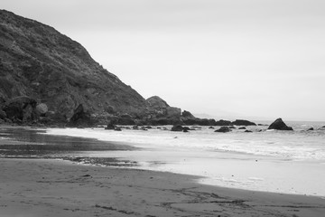 Ocean waves on a rocky shore in black and white