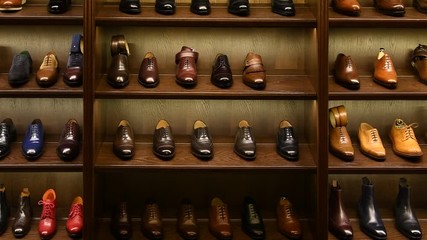 Full grain leather shoes on wooden display in men shoes boutique store. Black, brown and other colors. Zoom shot