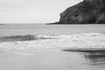 Fototapeta na wymiar Ocean waves on a rocky shore in black and white