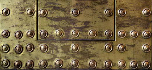 rusty and damaged metal plate with golden tone - worn steampunk background surface with screws and scratches