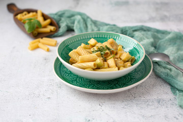 Vegan Rigatoni Dish in a Green Bowl on a White Background