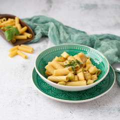 Vegan Rigatoni Dish in a Green Bowl on a White Background