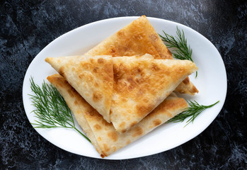 Dill pancakes with cream cheese filling on a white plate.