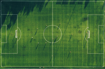 Aerial view of football club training. Big shadow on field.