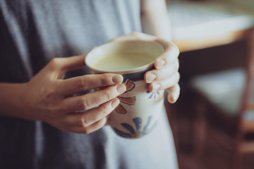 A person holding a mug of match tea 