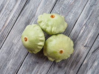 Pattypan squash on old rustic wooden background.