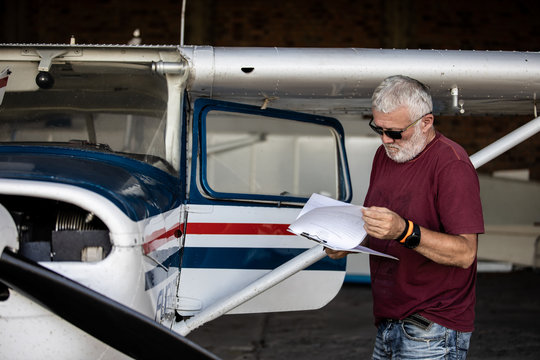 Senior man pilot checking ultralight airplane before flight