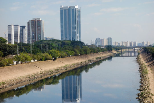 dark waters of Tiete river reflecting the sky and buildings. Sao Paulo, Brazil	