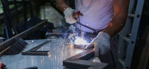 welder welds metal with a welding machine. metal works in the workshop close up. 