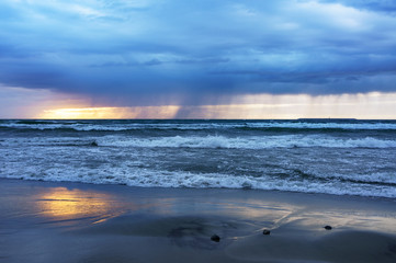 Sunset over the sea. Reflection of sunlight in the sea waves. The sky in the sunset rays.