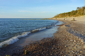 Sunset over the sea. Reflection of sunlight in the sea waves. The sky in the sunset rays.