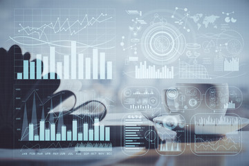 Double exposure of financial chart drawing and desktop with coffee and items on table background. Concept of forex market trading