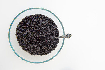 Bowl of Ripe Wild Elderberries on White Background