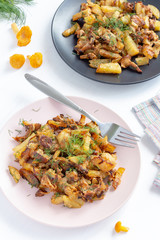 Fried forest chanterelle mushrooms with potatoes (Cantharellus cibarius). Two plates with delicious food