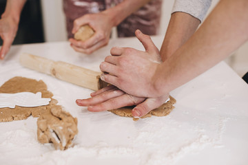Modeling ginger cookies. Two hands in the frame are making Christmas sweets out of brown dough. Preparation for the new year and Christmas. Cooking at home. Homemade cake. The homemade dough.
