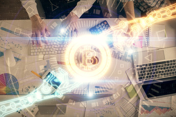 Double exposure of man and woman working together and crypto theme hologram drawing. Computer background. Blockchain concept. Top View.
