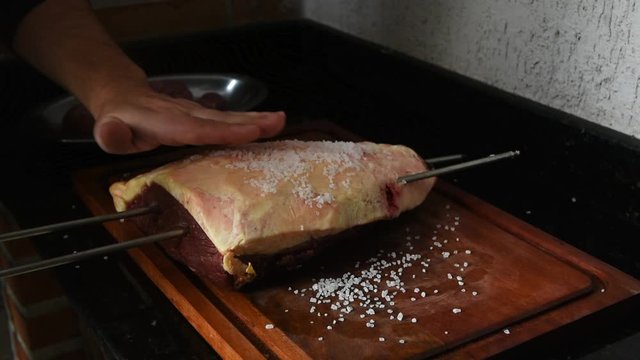 Salgando uma picanha para colocar na churrasqueira, tradicional churrasco do sul do Brasil feito em casa.
