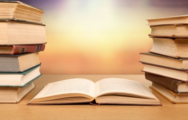 Stack open old books on wooden desk