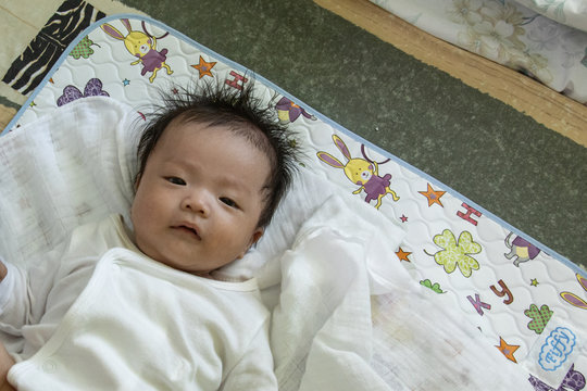 Portraiture image of Asian Cute little baby boy lying on bed