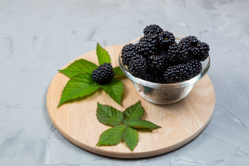 Ripe sweet blackberry on gray concrete background. Copy space
