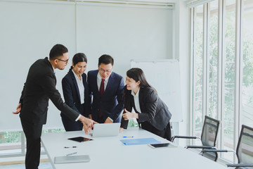 Asian company meetings for presentation as statistical graphs. The team of businessmen consulted about the marketing work in the meeting room of the workplace.