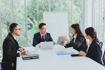 Asian company meetings for presentation as statistical graphs. The team of businessmen consulted about the marketing work in the meeting room of the workplace.