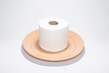 Toilet paper on the brown plate on white background