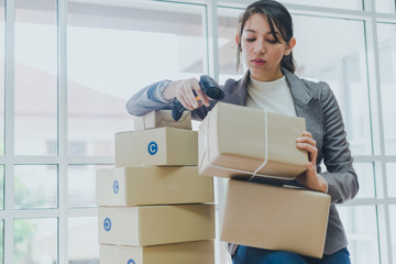 A beautiful businesswoman working at home is checking the amount of products that will be delivered to her customers.