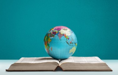 Heavy book and globe of a planet on the desk