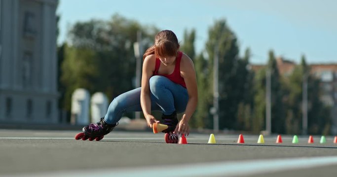 Roller skater makes a marking of the track, puts cones on the asphalt. Outdoor roller skating training. 4k, 10bit, ProRes