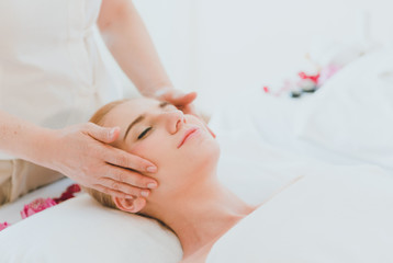 Beautiful woman lying on the bed for a spa asia massage at luxury spa and relaxation. The masseuse...