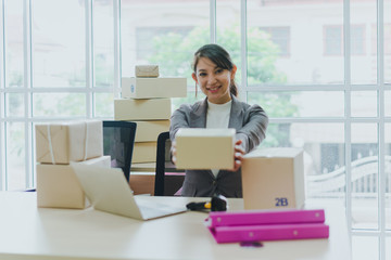 A beautiful businesswoman working at home is checking orders for products to be delivered to her...