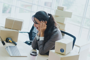 A beautiful businesswoman working at home is checking orders for products to be delivered to her...