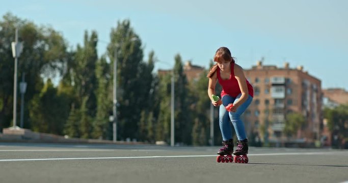 Pretty girl roller skates and puts cones, makes road markings. Roller skater starts training in an open area. 4k, 10bit, ProRes