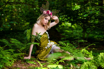 Portrait of Beautiful Sensual Caucasian Girl in Green Decorated Dress Posing in Forest Outdoor.