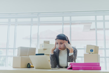 A beautiful businesswoman working at home is checking orders for products to be delivered to her...
