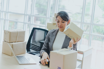 A beautiful businesswoman working at home is checking the amount of products that will be delivered...