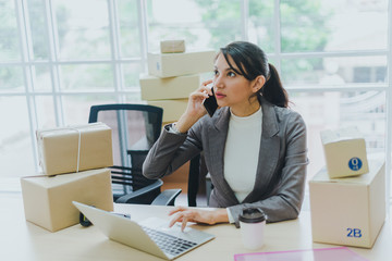 A beautiful businesswoman working at home is checking orders for products to be delivered to her...