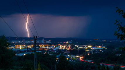 Naklejka na ściany i meble Lightning strike in the rain at night over City Zalaegerszeg