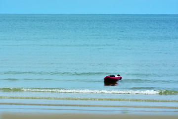 
On the beach a man rowing on the sea.