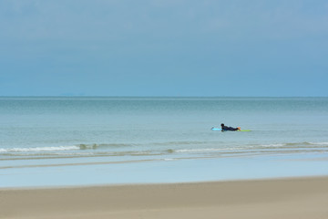 Fototapeta na wymiar On the beach a man rowing on the sea.