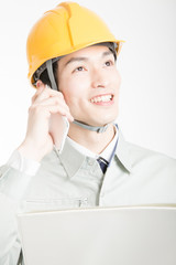 スマートフォンで通話する男性作業員