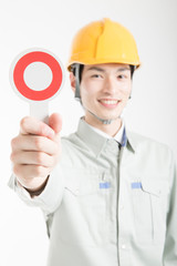 マルのプラカードを持った男性作業員