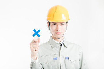 バツのプラカードを持った男性作業員