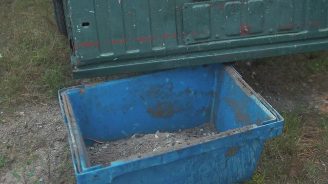 Sweeping gravel and sand from pickup truck bed into bucket