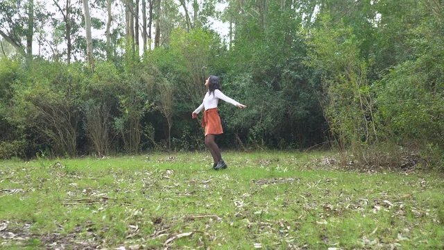 Free woman spinning around in a forest, slow motion