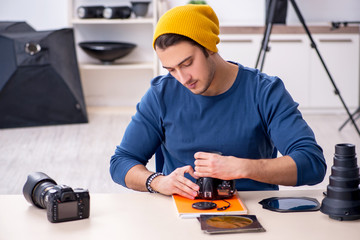 Young male photographer working in the studio