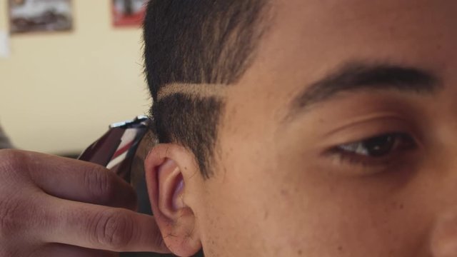 hairdresser performing a haircut following a division line for the male degrade